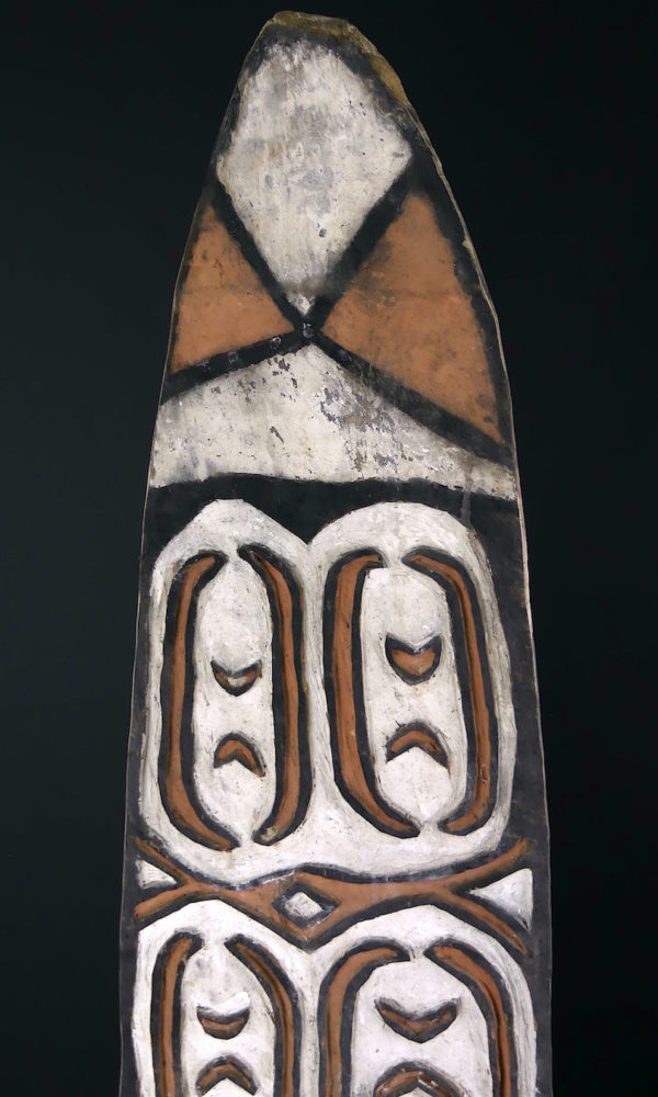 Grand bouclier de guerre Kombai en bois peint sur socle (détail face)