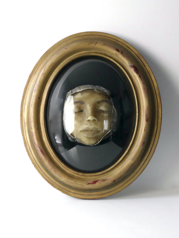 Petit visage en cire sous verre bombé (face)