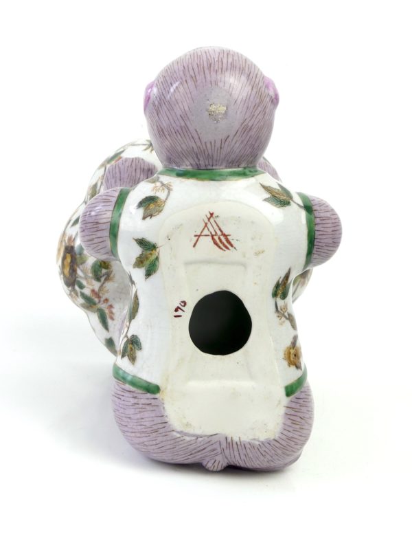Petit singe mauve portant une coupelle en céramique (dessous)