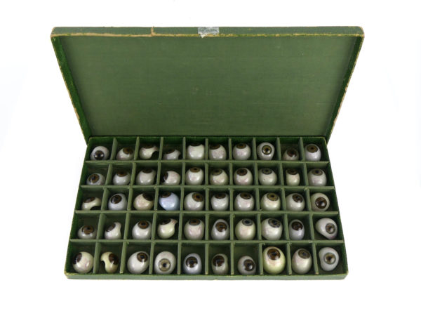 Boîte de 50 prothèses oculaires à l’iris brun et gris bleu (ouverte dessus)