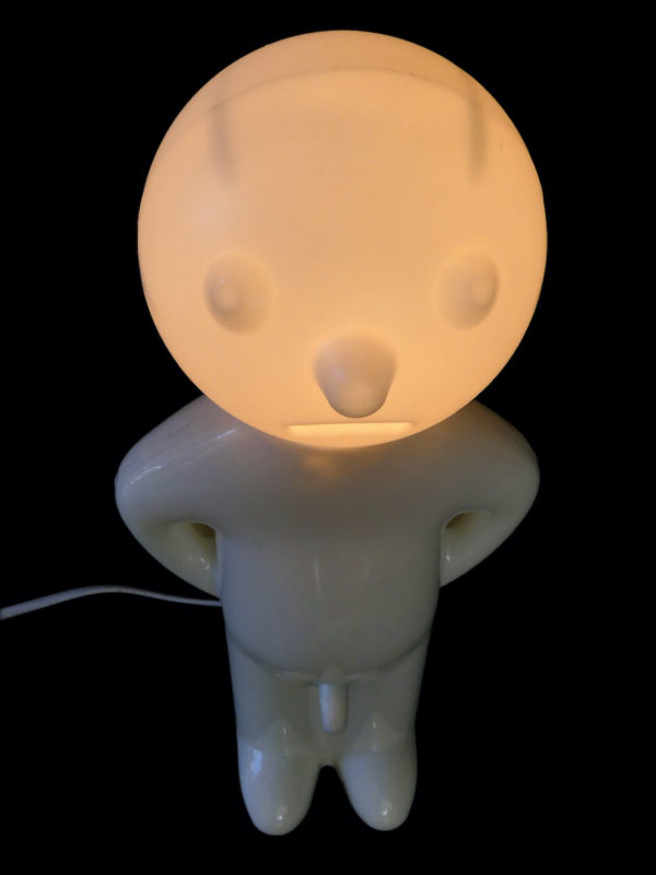 Lampe Mr. P blanche présentée sur socle rond (face allumée)