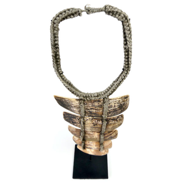 Collier papou en lamelles de coquillage sur base tressée sur socle (dessus)