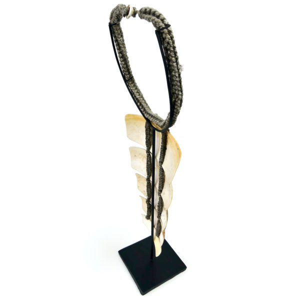 Collier papou en lamelles de coquillage sur base tressée sur socle (dessus 3/4)