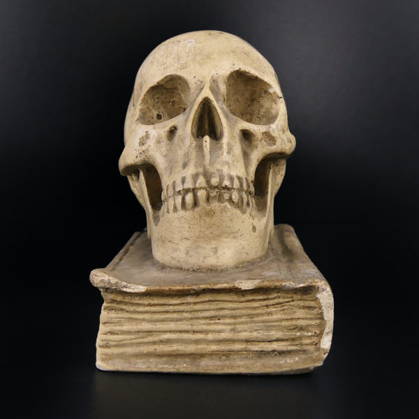 Petit crâne sur vieux livre relié en plâtre patiné Vanité Memento mori (face)