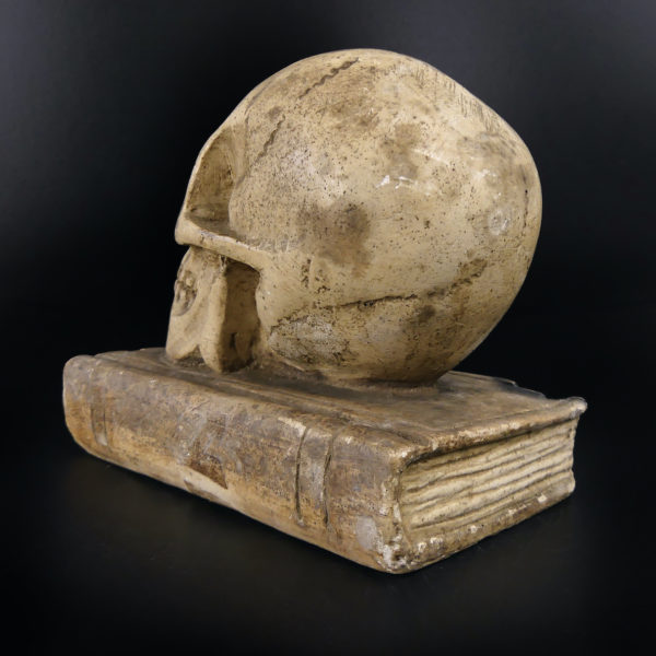 Petit crâne sur vieux livre relié en plâtre patiné Vanité Memento mori (3/4 dos)