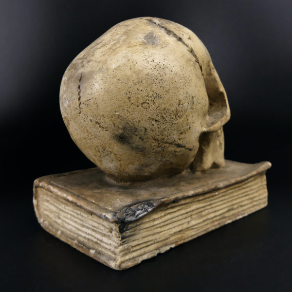 Petit crâne sur vieux livre relié en plâtre patiné Vanité Memento mori (3/4 dos)