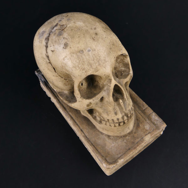 Petit crâne sur vieux livre relié en plâtre patiné Vanité Memento mori (dessus 3/4)