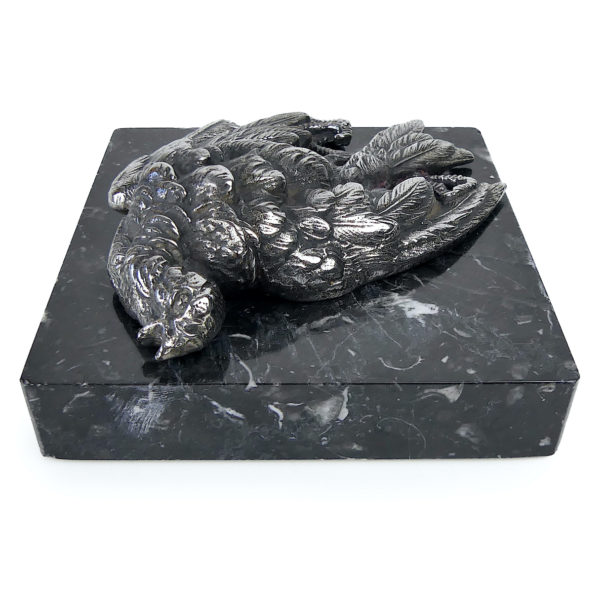 Petit oiseau mort en métal argenté sur plaque carrée de marbre noir (dessus 3/4)