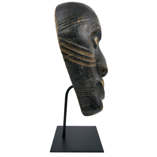 Masque de chaman asymétrique Tlingit en bois sur socle noir Amérique du Nord (profil)