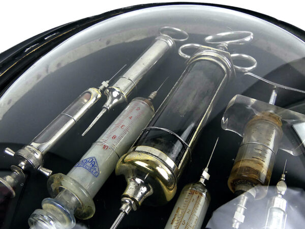 Seringues médicales anciennes cadre ovale en bois noir et verre bombé (détail)