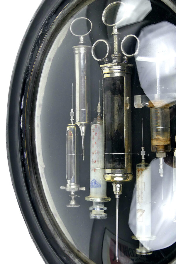 Seringues médicales anciennes cadre ovale en bois noir et verre bombé (détail)