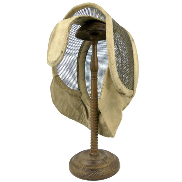 Masque d’escrime ancien en fil de fer et tissu écru sur porte-chapeau en bois tourné (3/4 dos)
