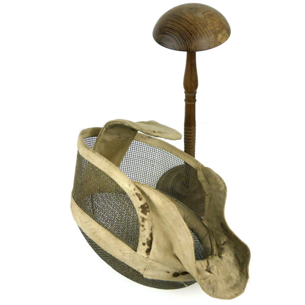 Masque d’escrime ancien en fil de fer et tissu écru sur porte-chapeau en bois tourné (3/4)