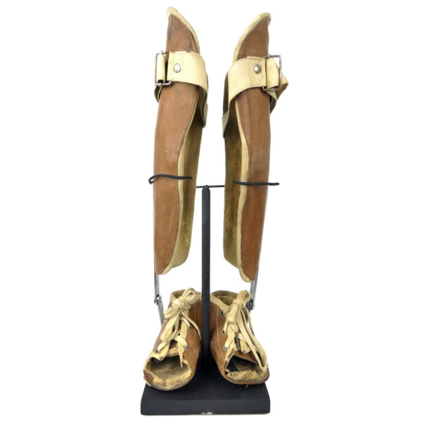 Paire orthèses orthopédiques infantiles de jambes en cuir moulé sur socle (face)
