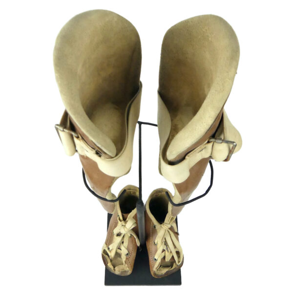 Paire orthèses orthopédiques infantiles de jambes en cuir moulé sur socle (dessus)