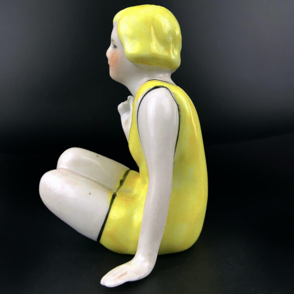 Petite baigneuse jaune en porcelaine assise en maillot Belle époque (profil)