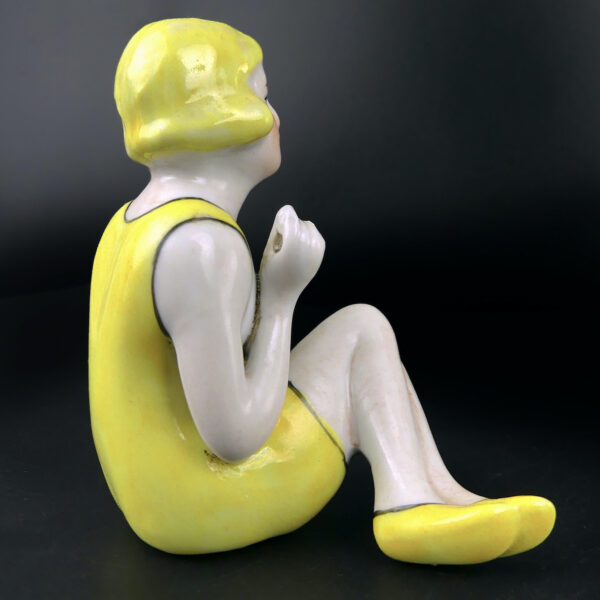 Petite baigneuse jaune en porcelaine assise en maillot Belle époque (profil)