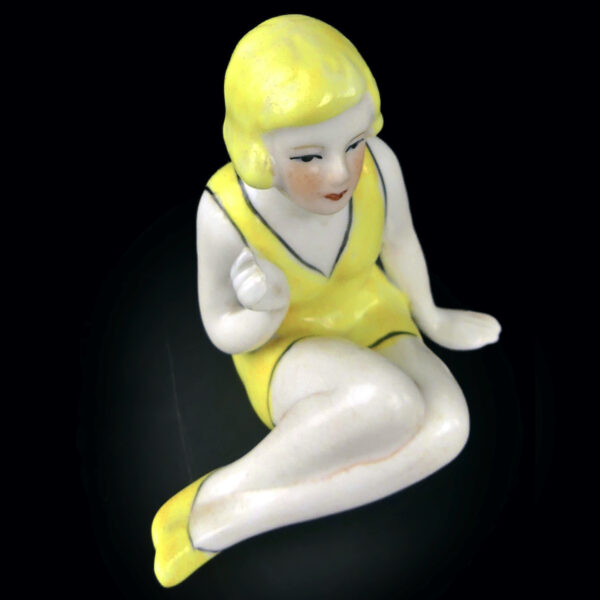 Petite baigneuse jaune en porcelaine assise en maillot Belle époque (dessus 3/4)