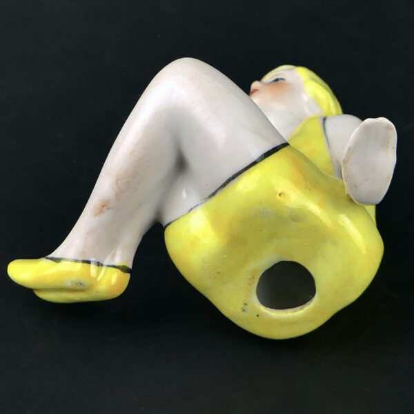 Petite baigneuse jaune en porcelaine assise en maillot Belle époque (dessous 3/4)